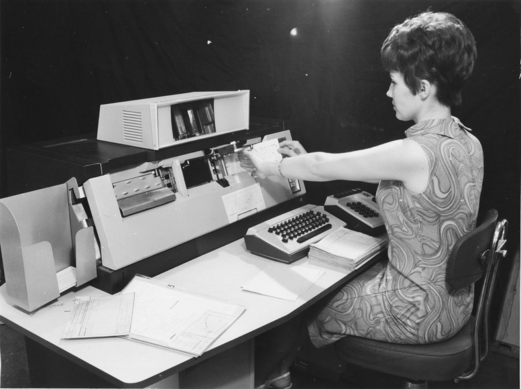 Woman operating vintage computing equipment.