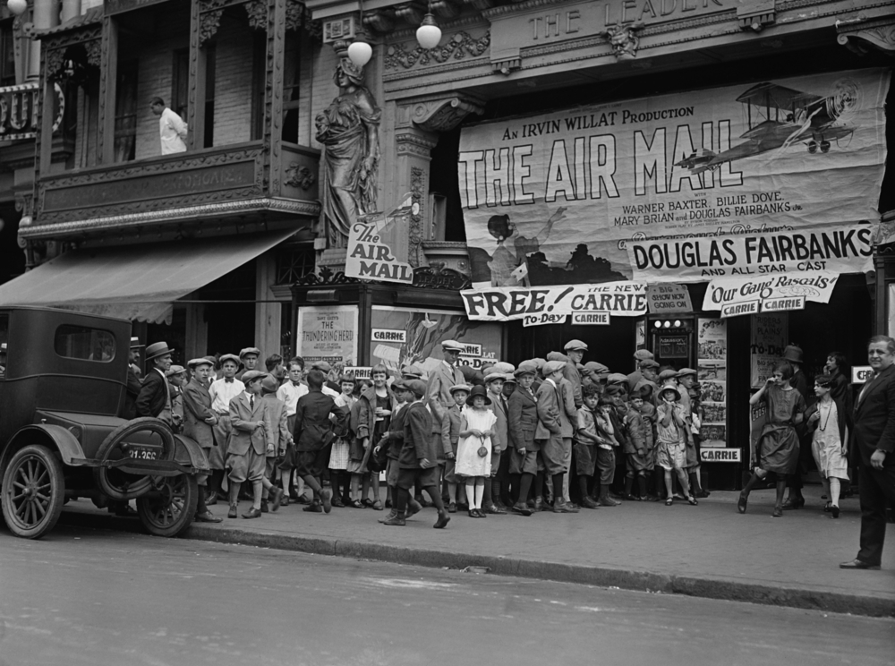Historic street scene with children gathering.