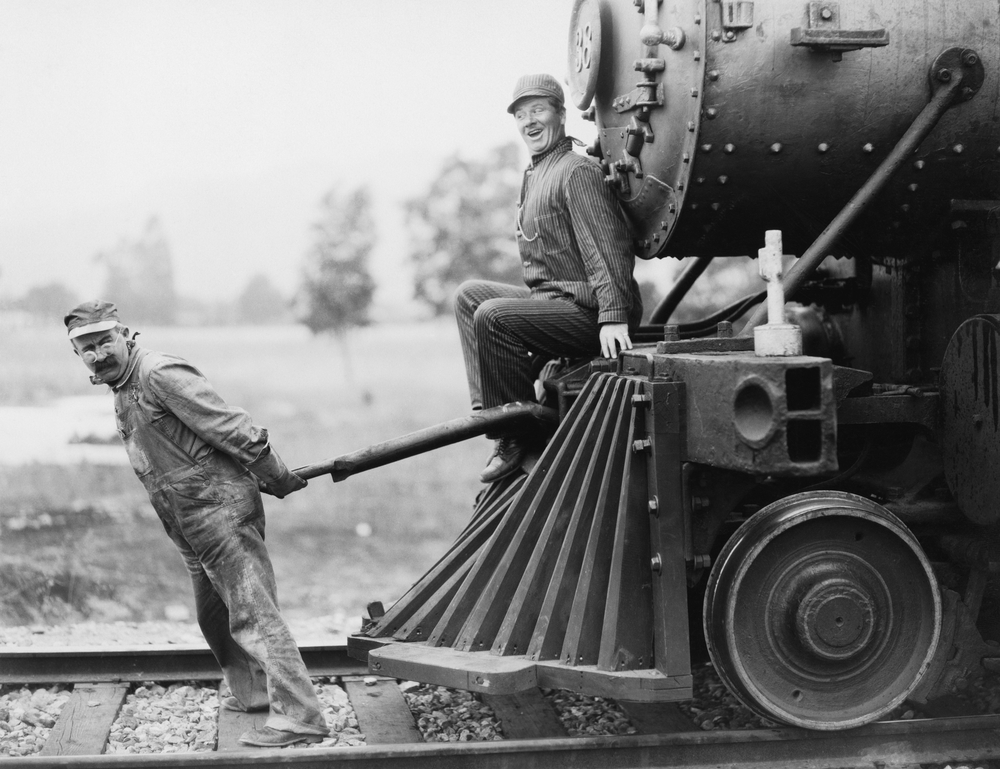 Two men with a vintage steam locomotive.