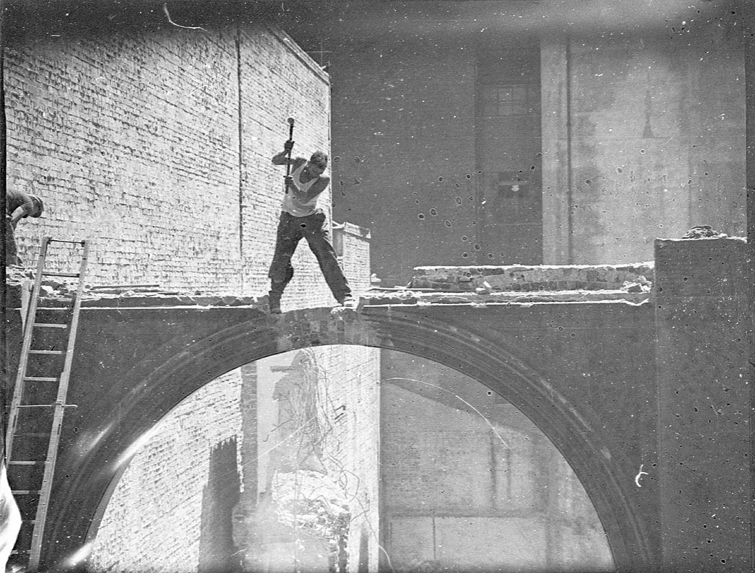 tumblr_oea9y5Ics11sfie3io1_1280 Archival black and white photograph of a laborer breaking down structure by hand, illustrating manufacturing capacity being reallocated